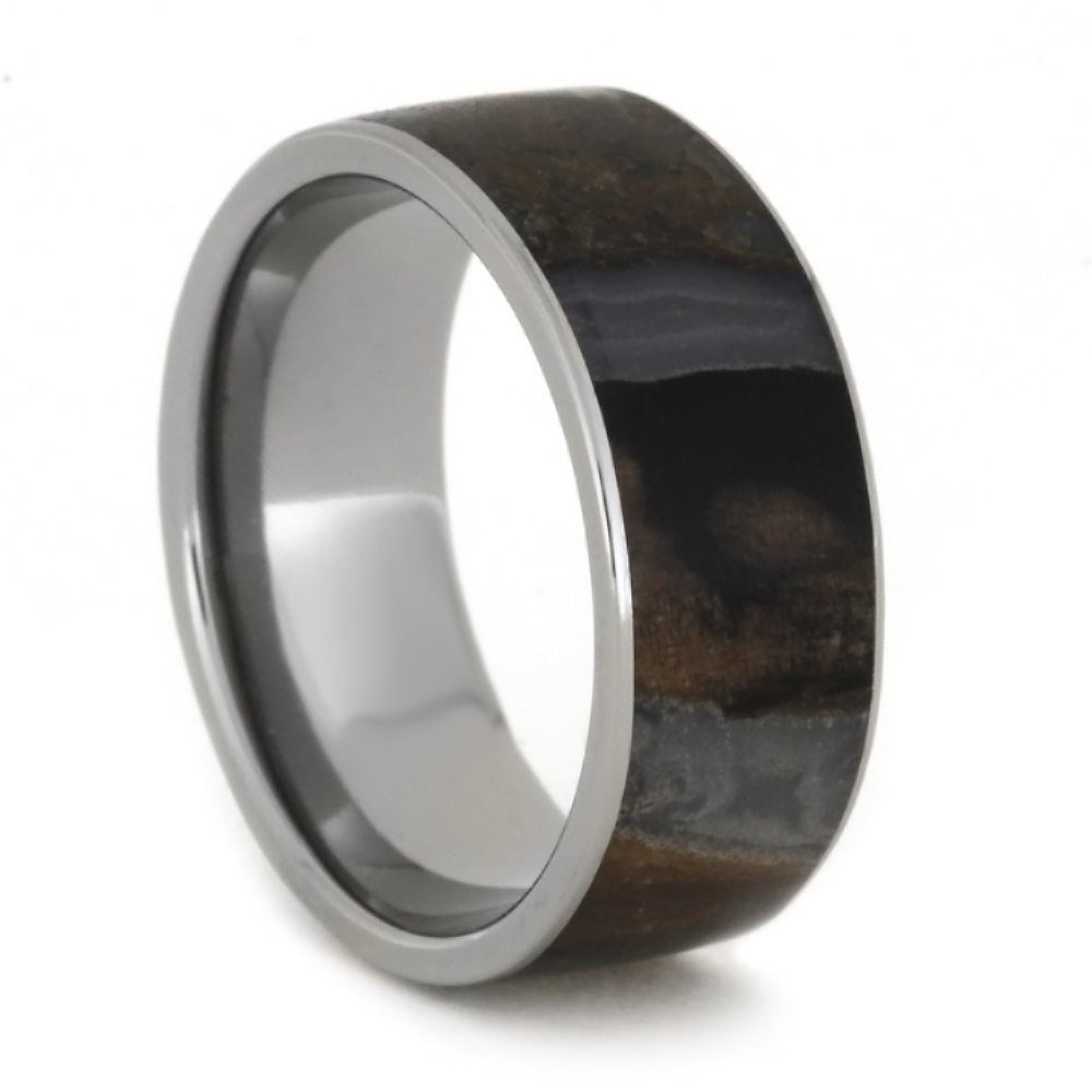 Solid titanium ring featuring petrified wood sporting beautiful colors. The blue and brown tones layer magically with each other. This rustic ring will help you make a bold statement to your style.
